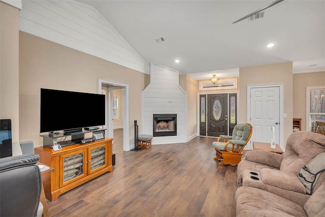 living room with lofted ceiling, a fireplace, and wood-type flooring