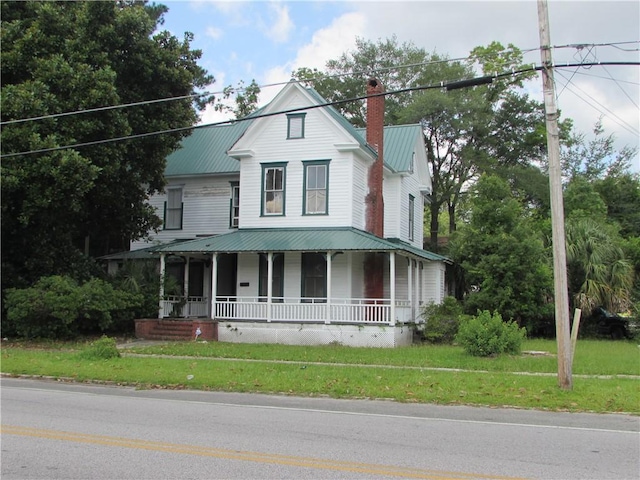 farmhouse inspired home featuring a front yard and a porch