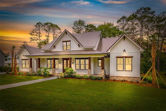 128 W Point Pkwy, Saint Simons Island, GA 31522 - modern farmhouse with board and batten siding, a porch, a front yard, a standing seam roof, and metal roof