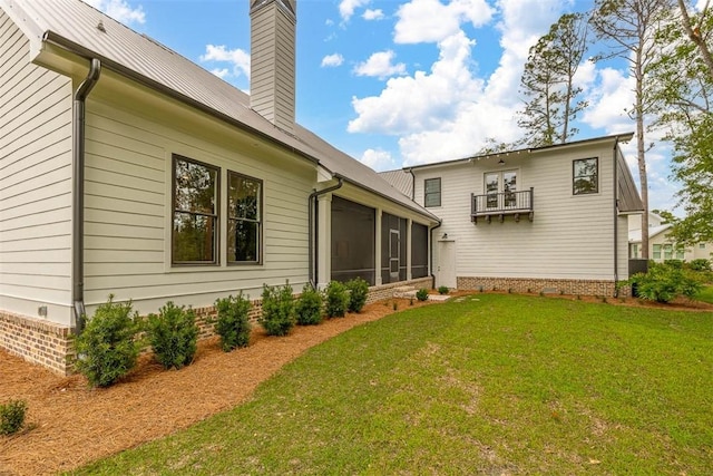 128 W Point Pkwy, Saint Simons Island, GA 31522 - rear view of property featuring a chimney, a lawn, a sunroom, and a balcony