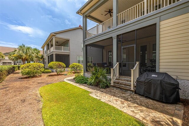 doorway to property featuring a yard, ceiling fan, and a balcony