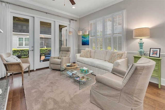 living room with wood-type flooring, ceiling fan, and crown molding