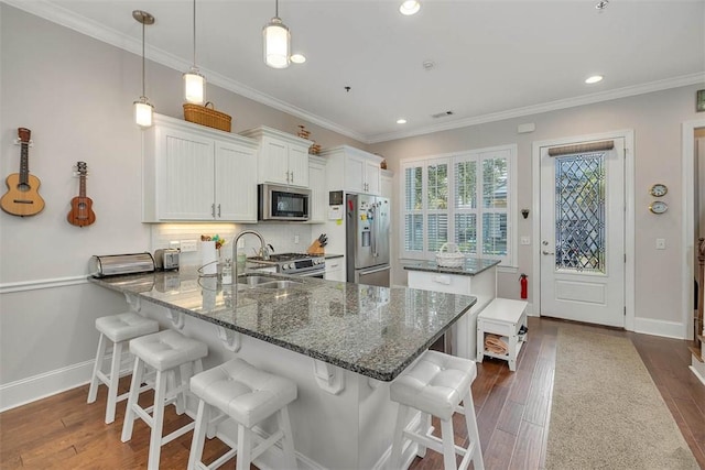 kitchen with kitchen peninsula, stainless steel appliances, dark wood-type flooring, white cabinetry, and hanging light fixtures