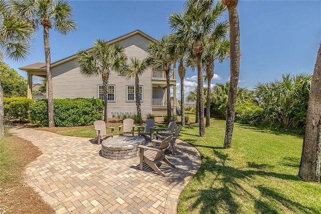 view of patio with a fire pit and a balcony