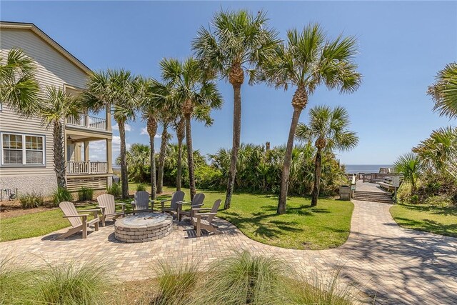 view of home's community featuring a lawn, a patio area, and a fire pit