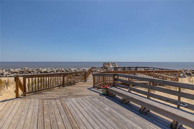 view of community with a deck with water view