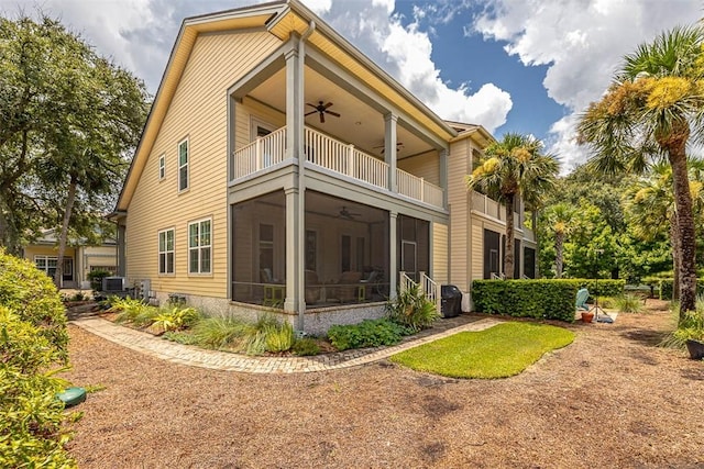 rear view of house featuring ceiling fan and a balcony