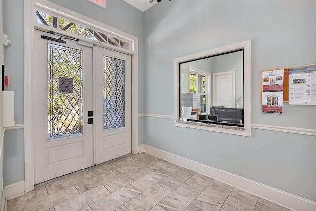 foyer entrance with french doors and a healthy amount of sunlight