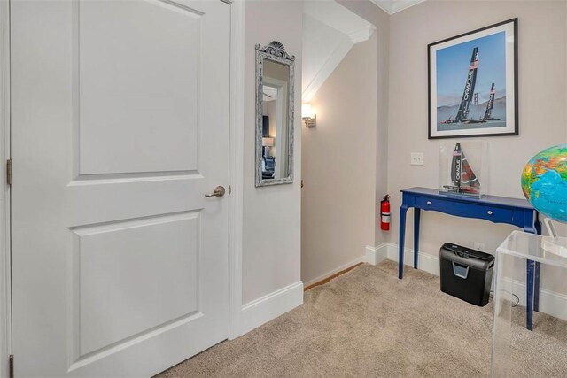 corridor with light carpet and crown molding