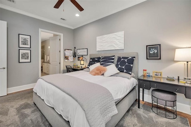 bedroom featuring ensuite bath, ceiling fan, dark wood-type flooring, and crown molding