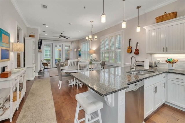 kitchen featuring dishwasher, white cabinets, wood-type flooring, and sink