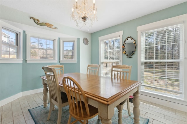 dining area with a healthy amount of sunlight, an inviting chandelier, baseboards, and wood finished floors