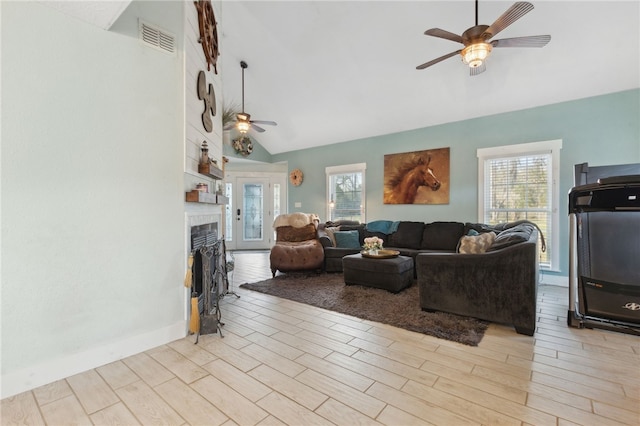 living area featuring a fireplace, wood finished floors, visible vents, and a ceiling fan