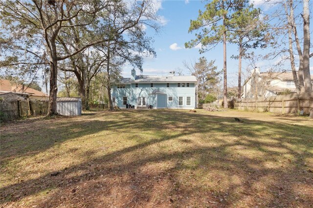 view of yard featuring a fenced backyard, an outdoor structure, and a storage unit