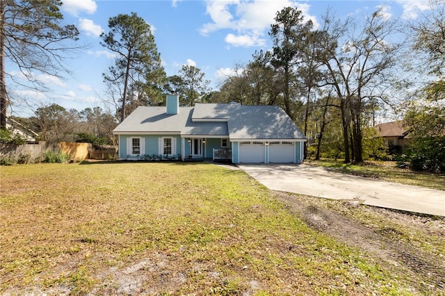view of front of house featuring a chimney, a front yard, fence, a garage, and driveway