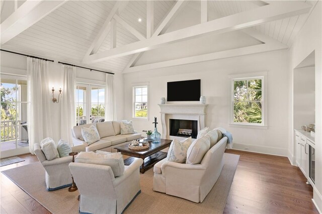 living room featuring hardwood / wood-style floors, high vaulted ceiling, and beamed ceiling