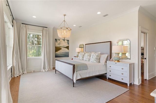 bedroom featuring dark hardwood / wood-style floors, an inviting chandelier, and crown molding