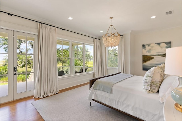 bedroom with access to outside, hardwood / wood-style flooring, ornamental molding, and a notable chandelier