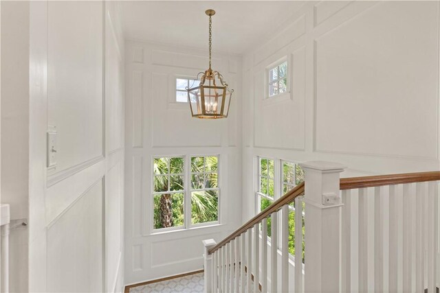 staircase with a notable chandelier