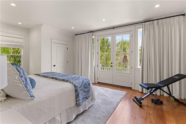 bedroom featuring french doors, access to outside, and hardwood / wood-style flooring