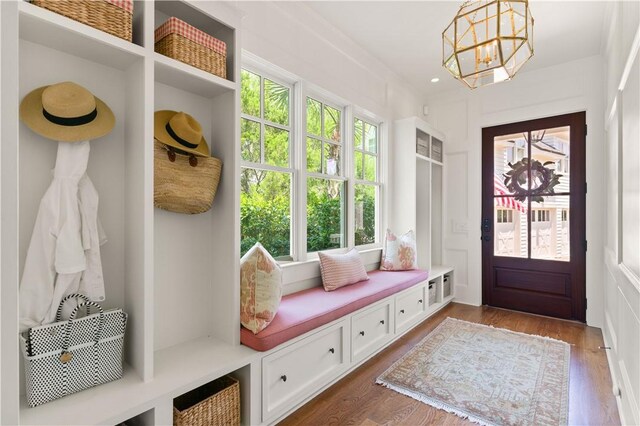 mudroom with an inviting chandelier, a healthy amount of sunlight, and wood-type flooring