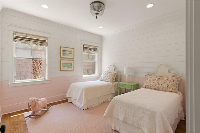 bedroom with hardwood / wood-style floors, ornamental molding, and multiple windows