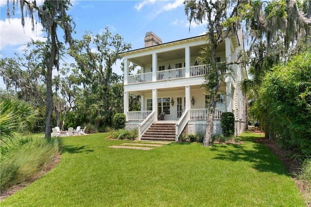 view of front of house featuring a balcony, a front lawn, and a porch