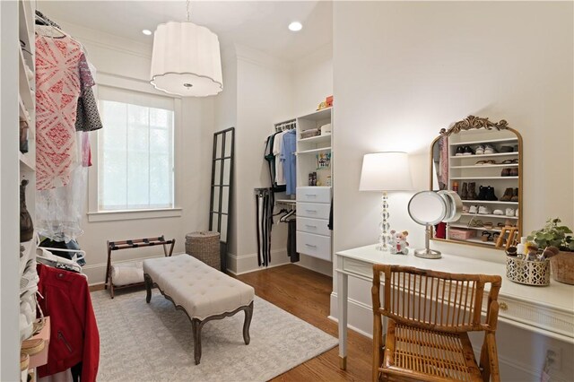 living area with hardwood / wood-style flooring and crown molding