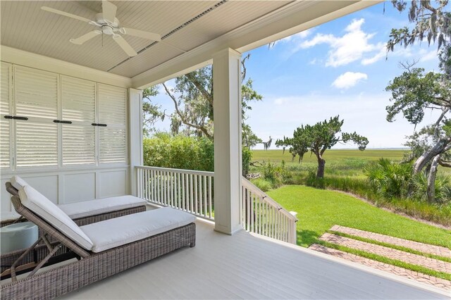 exterior space with a lawn, ceiling fan, a rural view, and covered porch