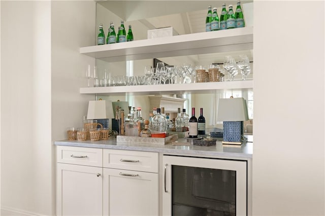 bar with white cabinets and beverage cooler