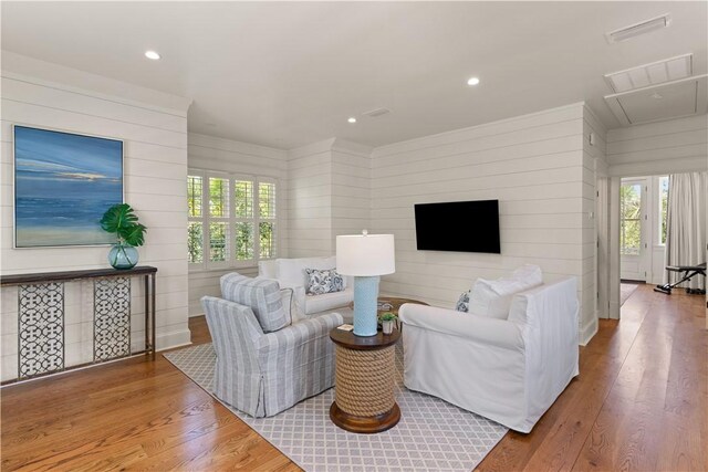 living room with hardwood / wood-style flooring and wood walls