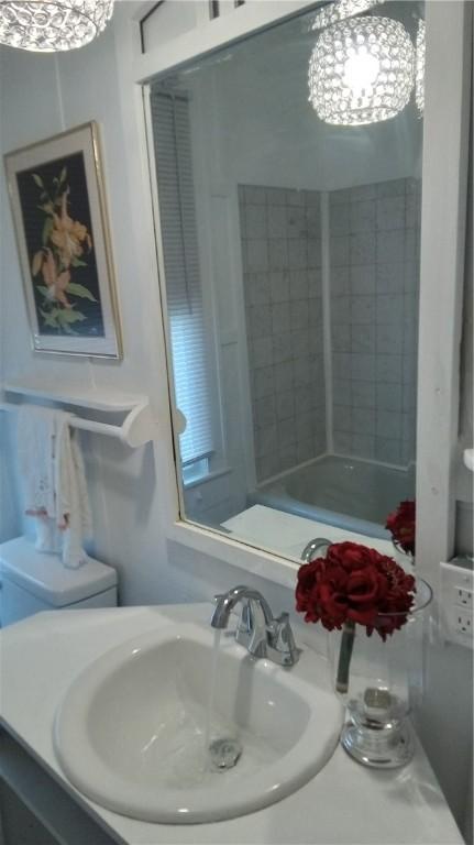 bathroom with a notable chandelier and sink