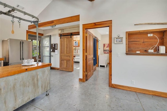 1106 George Lotson Ave, Saint Simons Island, GA 31522 - kitchen featuring high end fridge, high vaulted ceiling, visible vents, concrete flooring, and baseboards