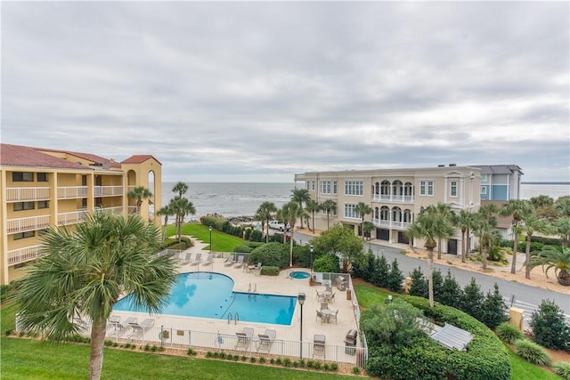 view of swimming pool with a water view and a patio