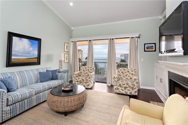 living room featuring hardwood / wood-style flooring, vaulted ceiling, and ornamental molding