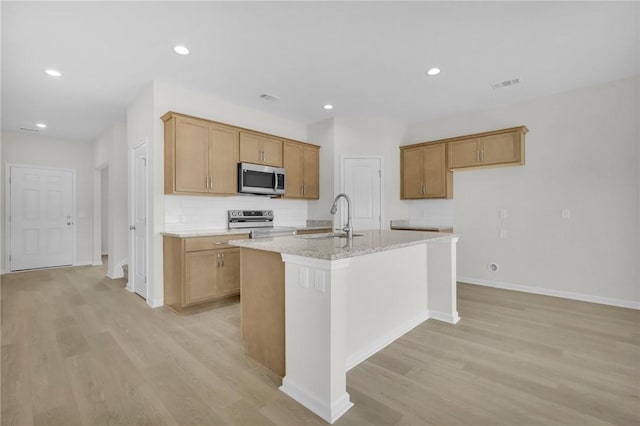 11026 Woodland Trl, Brunswick, GA 31525 - kitchen with stainless steel appliances, a sink, a center island with sink, light wood-style flooring, and recessed lighting