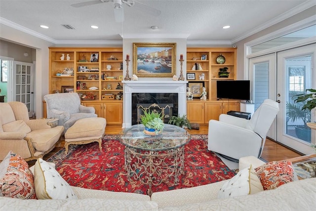 living room with hardwood / wood-style floors, ornamental molding, and a fireplace