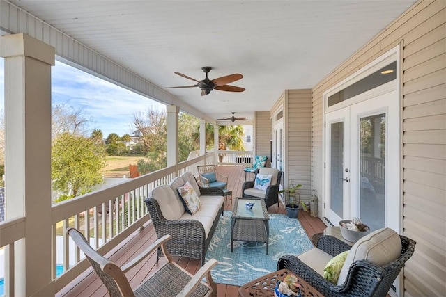 wooden deck with an outdoor living space, ceiling fan, and french doors