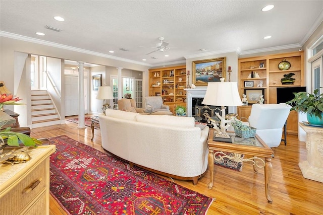 living room featuring light hardwood / wood-style flooring, a wealth of natural light, ornamental molding, and ceiling fan