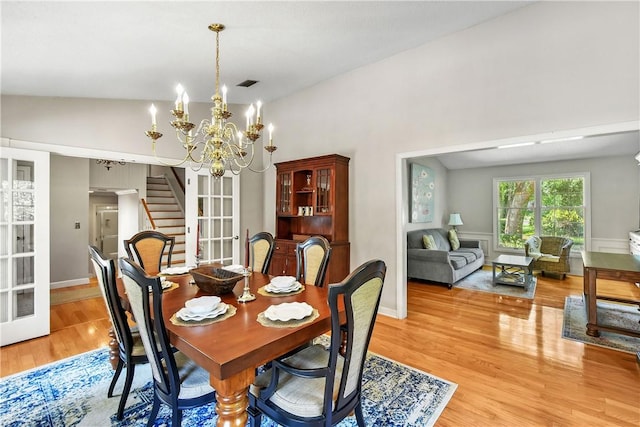 dining room featuring a chandelier, light hardwood / wood-style flooring, and vaulted ceiling