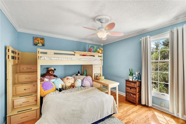 bedroom with a textured ceiling, light hardwood / wood-style floors, ceiling fan, and crown molding