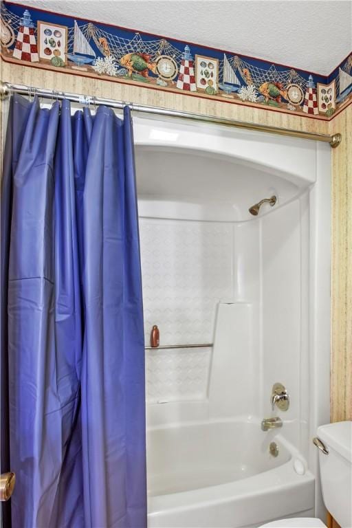 bathroom with a textured ceiling, toilet, and shower / bath combo with shower curtain