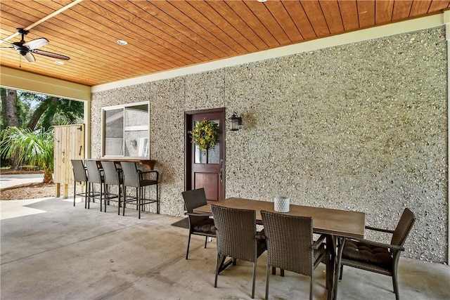 view of patio / terrace with ceiling fan and a bar