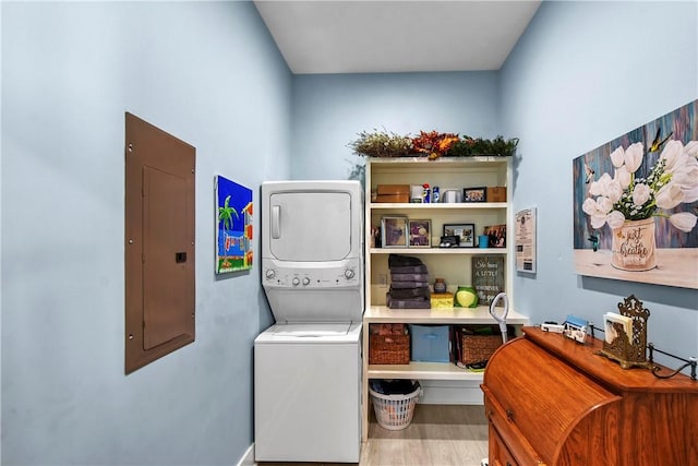 laundry room with light hardwood / wood-style floors, electric panel, and stacked washer and clothes dryer