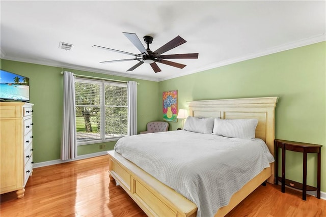 bedroom featuring light hardwood / wood-style flooring, ceiling fan, and crown molding