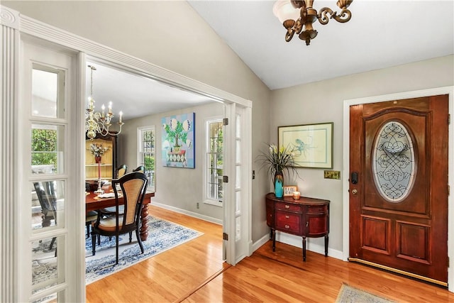 foyer entrance featuring a chandelier, light hardwood / wood-style floors, and lofted ceiling