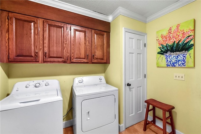 clothes washing area with cabinets, crown molding, light hardwood / wood-style flooring, a textured ceiling, and washing machine and clothes dryer