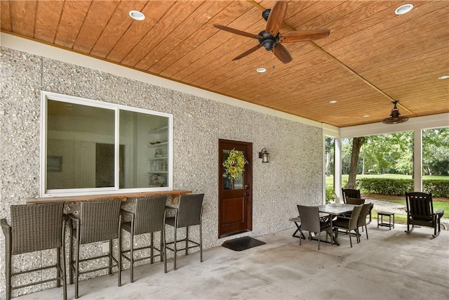 view of patio with ceiling fan and an outdoor bar