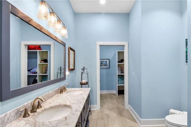 bathroom with hardwood / wood-style floors, vanity, and toilet