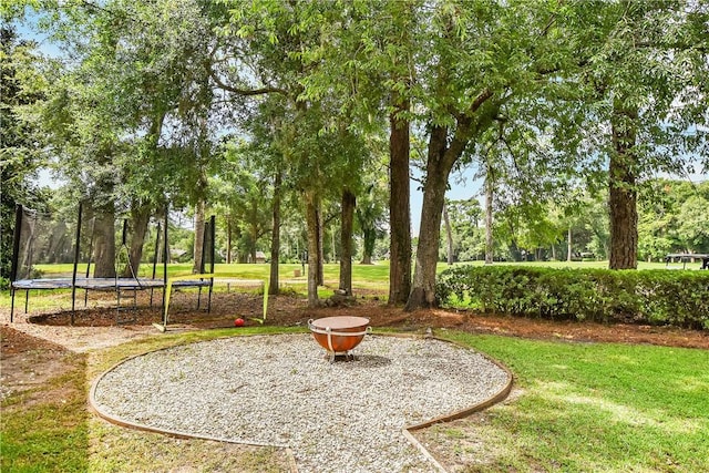 view of property's community featuring a trampoline and a yard